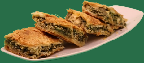 Byrek me spinaq, i prerë në copa, në pjatë të bardhë