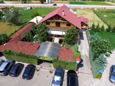 Pamje nga lart e restorantit, me çatën e kuqe dhe parkimin përreth